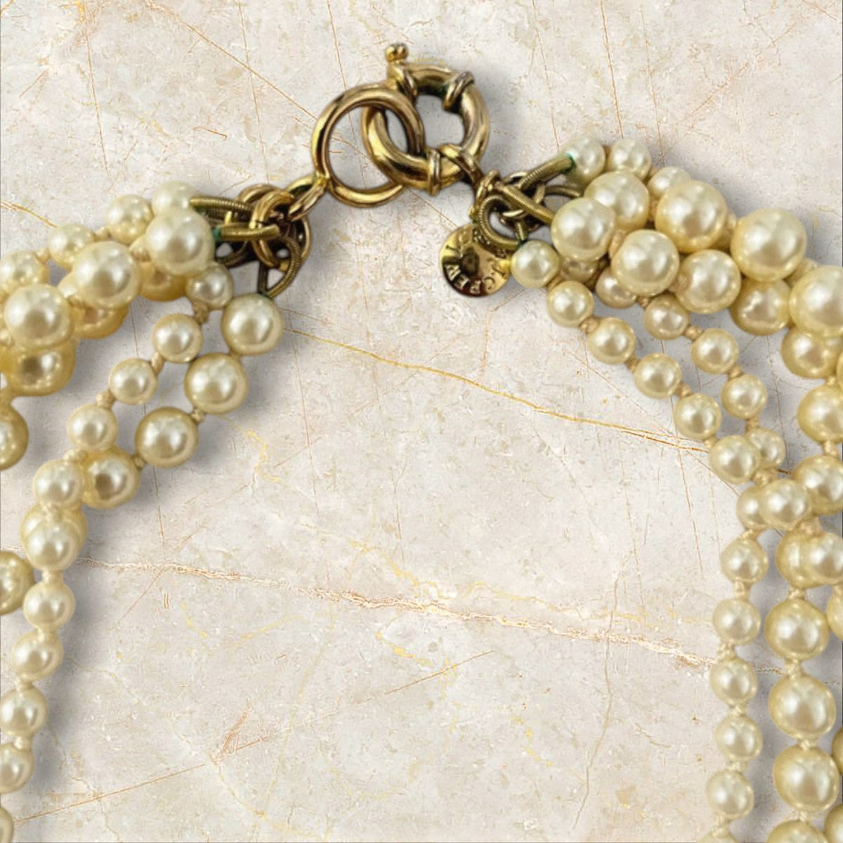 Velvet Leopard Vintage NYC multi-strand faux pearl statement necklace with gold-tone clasp and branded charm